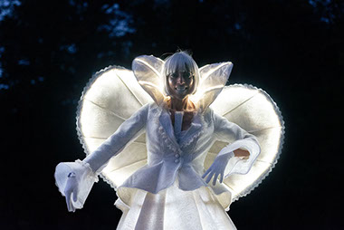 échassiers blancs lumineux en animation déambulatoire féerique. Artistes de cirque en parade pour animer les évènements de ville, mairie