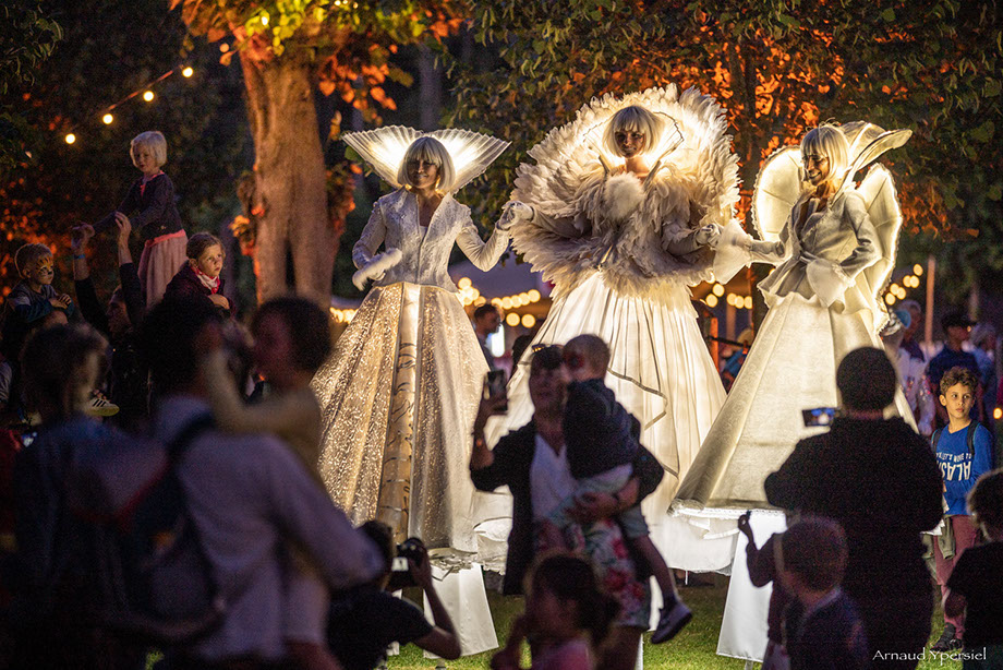 échassiers lumineux et blancs en animation et déambulation de rues. Parade en musique et danse dans les rues de votre ville pour une animation 