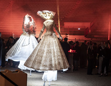 échassiers en déambulation sous forme d’animation ou de parade de rue. Artistes en costumes blancs et lumineux dansant sur échasses. Animation