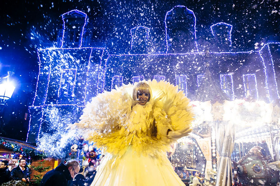 Echassiers de noël en déambulation avec échassiers lumineux et costumes blancs pour un spectacle de rue et vivant féerique. paris, ile de France
